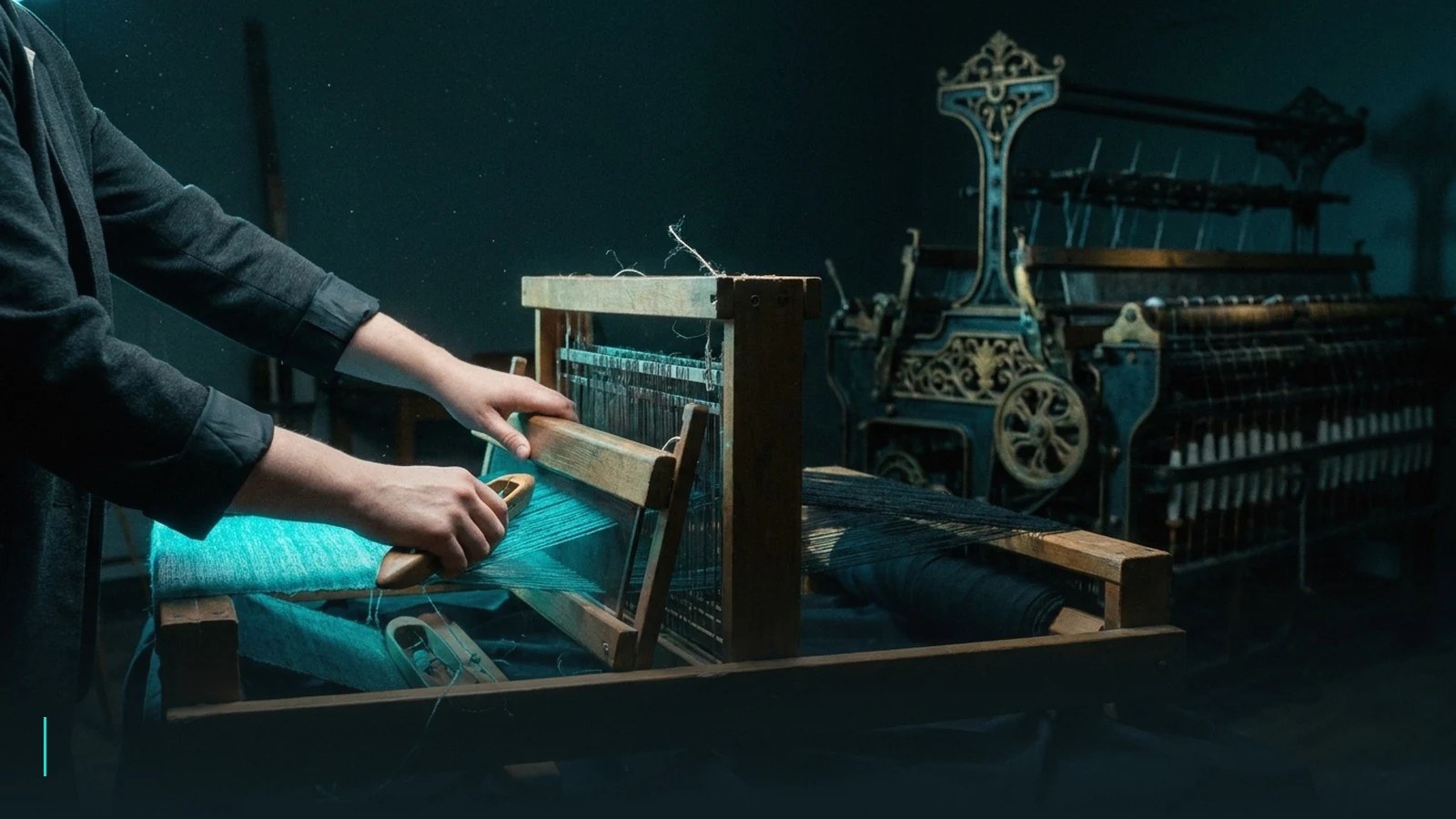 A small hand-loom weaving glowing cloth beside a dormant industrial textile machine with empty spindles.