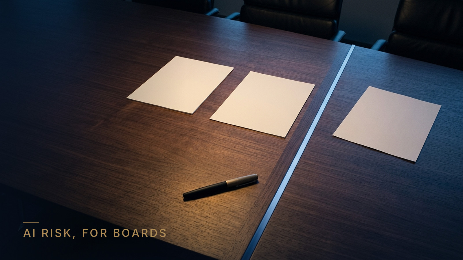 A dark walnut boardroom table seen from above, split by a thin strip of cool blue light. A brass-capped pen and one sheet rest on the warm side; one sheet stops just short of the line and one lies askew beyond it. Label: AI risk, for boards.